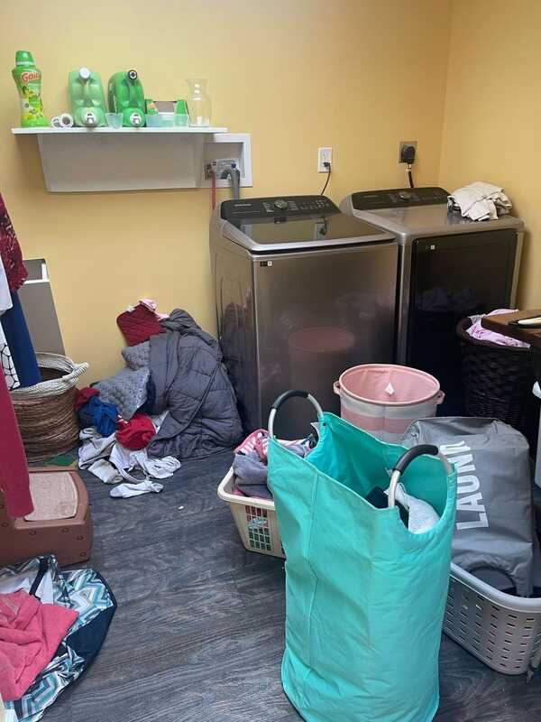 Laundry room with clothes and baskets on the floor, before cleaning
