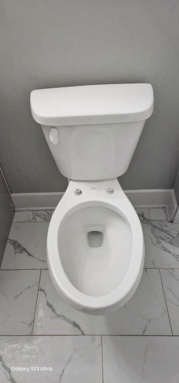 Toilet with the seat removed so the hinge area can be cleaned