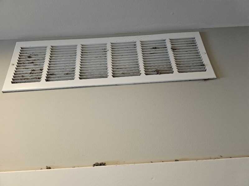 Dust buildup on a wall vent cover before cleaning